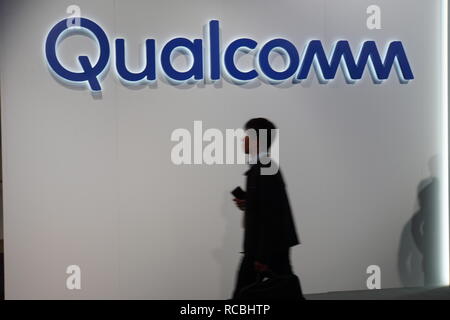 Las Vegas, USA. 09 Jan, 2019. Die Besucher der CES Elektronik Messe vorbei an einem Qualcomm Logo. Der Chiphersteller hatte einen Rückschlag in seiner Patentstreit gegen Apple am Dienstag zu akzeptieren. Das Landgericht Mannheim hat entschieden, dass das iPhone von Apple nicht Qualcomm Patente verletzen. Credit: Christoph Dernbach/dpa/Alamy leben Nachrichten Stockfoto