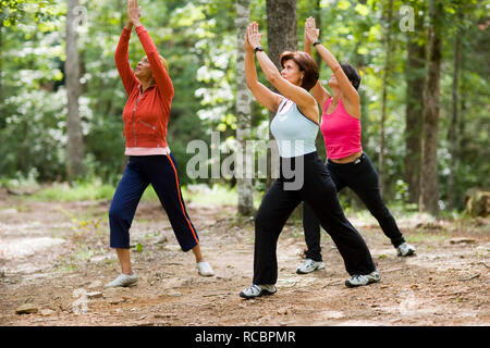 Im mittleren Alter Frauen Yoga im Wald Stockfoto