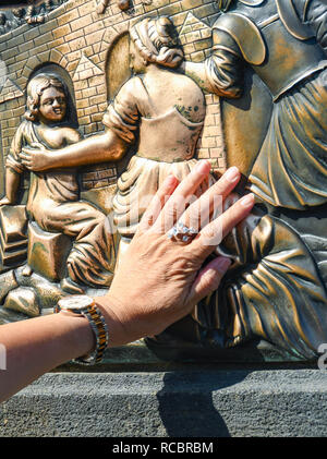 Prag, tschechische Republik - Juli 2018: Person reiben die Bronzetafel des Hl. Johannes auf ein Statut auf der Karlsbrücke in Prag. Stockfoto