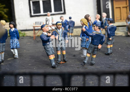 Schulkinder über dem Schultor im Bekonscot Model Village, Beaconsfield, Buckinghamshire, Großbritannien Stockfoto