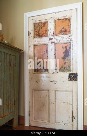 Alte hölzerne Schrank Tür mit blass weiß und orange Farbe im Obergeschoss Schlafzimmer innerhalb eines alten 1835 fieldstone Haus Stockfoto