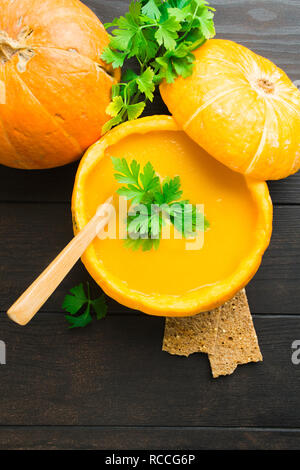 Frische organische Vegetarische gesunde Kürbissuppe mit Petersilie Holztisch, flach Stockfoto