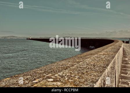 Die holyhead Wellenbrecher mit der Breakwater Leuchtturm in der Ferne, Holyhead, Anglesey, North Wales, UK Stockfoto