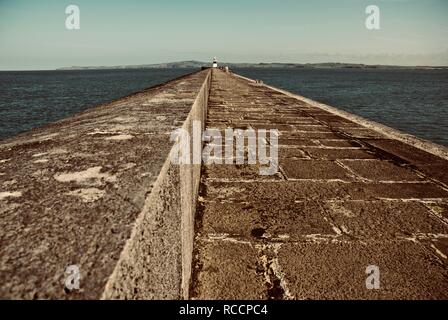 Die holyhead Wellenbrecher mit Breakwater Leuchtturm in der Ferne, Holyhead, Anglesey, North Wales, UK Stockfoto