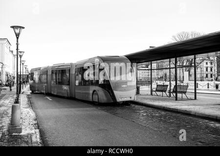 Malmö, Schweden - 29 DEZ 2014: moderne Doppel gelenkbus Van Hool 324 H Exequicity 24 Hybrid betrieben von Skanetrafiken Ankunft in Bus Station an einem kalten Wintertag - ökologische öffentliche Verkehrsmittel Schwarz und Weiß, Stockfoto