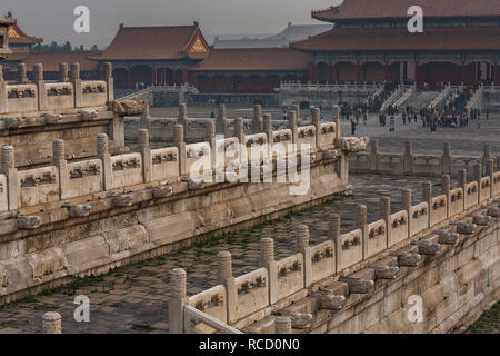 Nahaufnahme der kunstvoll geschnitzten Steinwände und eine Reihe von roten Ziegeldächern innerhalb der Verbotenen Stadt in Peking, China Stockfoto