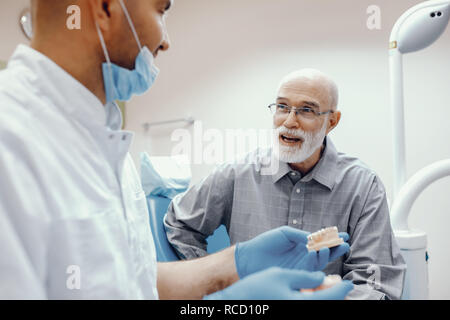 Alte Mann sitzt in der Zahnarztpraxis Stockfoto