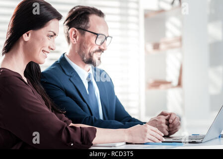 Freudige zwei Kollegen mit Schwerpunkt auf der Arbeit Stockfoto