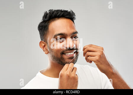 Inder mit Zahnseide reinigen Zähne Stockfoto