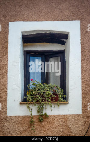 Sehr alte Fensterrahmen nach innen öffnen und wieder zurück in einem alten französischen Hauswand mit Pflanzmaschine auf den Fenstersims setzen Stockfoto