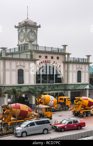 Die Insel Hongkong, China - 14. Mai 2010: Historische Central Pier Gebäude mit gelben und roten Fahrmischer vor, weil der Bau Stockfoto