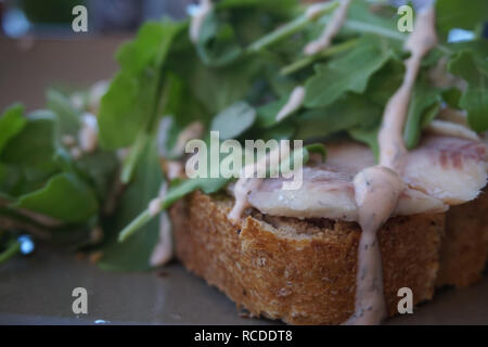 Öffnen konfrontiert Fisch Sandwich mit Niederländischen erblassen (geräucherter Aal). Mit Rucola Grüns gekrönt und mit Dressing beträufelt. Berühmte Gericht in Bunschoten-Spakenburg. Stockfoto