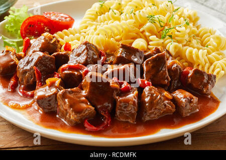 Würzige wild Wildgulasch mit Reh Reh mit Pasta Nudeln in der Nähe zu sehen, für ein Menü serviert. Stockfoto