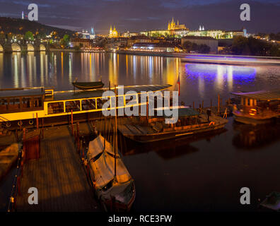 Prag - Karlsbrücke, Schloss und Kathedrale mit dem kleinen Hafen in der Dämmerung. Stockfoto