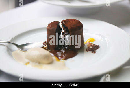 Makro Foto der süßen Schokolade Kuchen mit Eis auf weißen Tisch Stockfoto