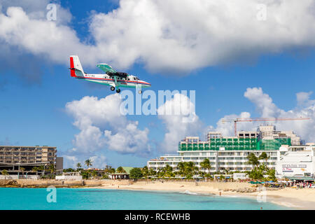 De Havilland Canada DHC -6-300 Twin Otter, PJ-WIU, Winair - Windward Islands Airways fliegen in niedrig über Moho Bay in Princess Juliana Flughafen in St. Ma Stockfoto