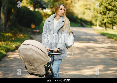 Junge Mutter mit dem Kinderwagen schieben Stockfoto