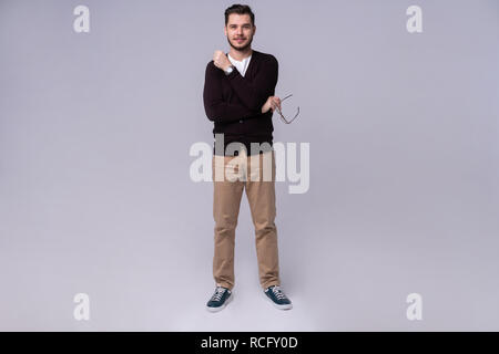 Jungen gutaussehenden Mann denken über grauen Hintergrund. Stockfoto