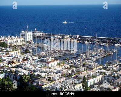 Blick über den malerischen Hafen von Puerto de Mogan, Gran Canaria auf den Kanarischen Inseln, mit Segelbooten und ein blaues Meer und Himmel Stockfoto