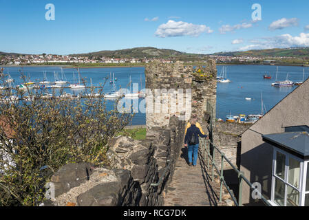 Alte Stadtmauer in Conwy, North Wales. Blick auf die Boote im Fluss in der Nähe des Hafens. Deganwy auf der gegenüberliegenden Seite. Stockfoto