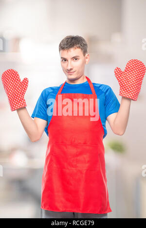 Mann in eine Schürze und Handschuhe für heiße auf weißem Hintergrund in der Küche Stockfoto