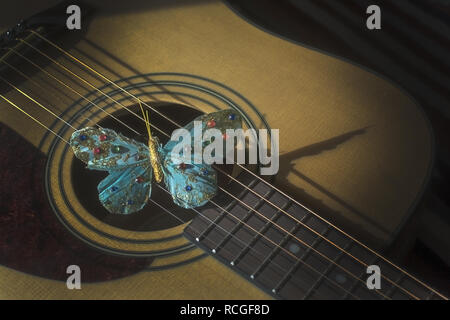 Türkis Schmetterling auf Saiten der Gitarre, Konzept für Poesie, Musikalität, Singer Songwriter Kreativität. Stockfoto