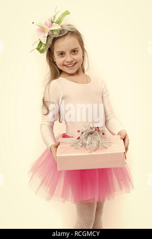 Mädchen ballerina Lächeln mit Box im rosa Tutu Rock. Kind mit Blume im langen blonden Haare isoliert auf Weiss. Urlaub, Geburtstag, Jubiläum zu feiern. Vorhanden oder Geschenk geben. Boxing Day Konzept. Stockfoto