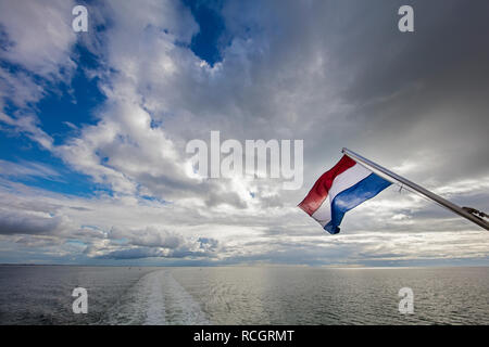 Die Niederlande, Vlieland, Wattenmeer, UNESCO-Weltkulturerbe. Niederländische Flagge von der Fähre. Stockfoto