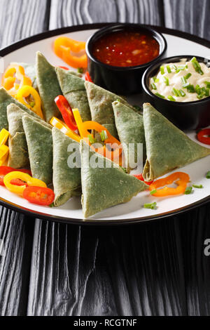 Leckere frittierte grüne Samosa mit Saucen und Paprika closeup auf einem Teller auf den Tisch. Vertikale Stockfoto