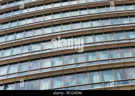 London Marriott Hotel Canary Wharf. Glas Fenster Fassade des Bürogebäudes, Skyscraper oder Hotel mit Wolken und Himmel spiegelt sich auf der Oberfläche. Stockfoto