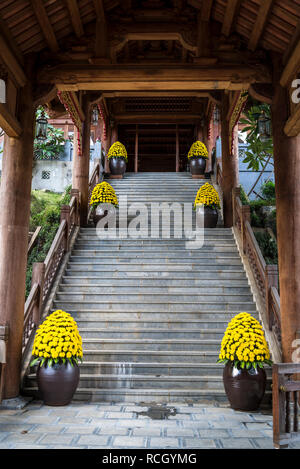 Bai Dinh buddhistischen Tempel, prächtige Treppe mit riesigen Blumentöpfe mit gelben Blumen, Provinz Ninh Binh, Vietnam Stockfoto