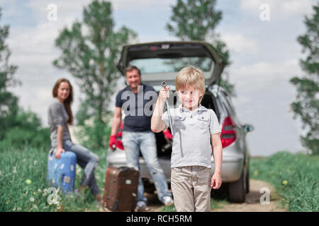 Junge mit einem Schraubenschlüssel auf einer Landstraße. Mühe auf der Straße Stockfoto