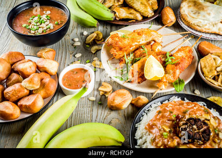 West African food Konzept. Traditionelle Wset afrikanische Gerichte Sortiment - peanut Soup, jollof Reis, gegrillte Chicken Wings, chemische gebratene Bananen Bananen, Stockfoto