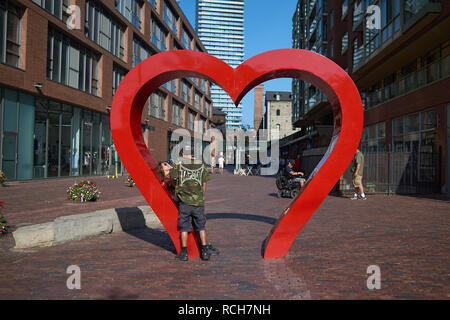 Junge Liebhaber stehen unter einem heartshaped Statue auf den Straßen von Toronto im Sommer Sonnenschein Stockfoto