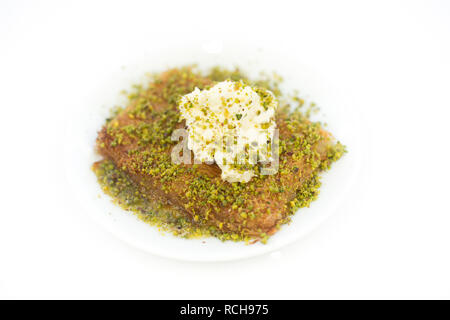 Traditionelles türkisches Dessert bekannt als 'Kunefe' oder Kunafah oder Kunafa Kunafeh oder Kadayif. Im Nahen und Mittleren Osten Dessert, Pistazien und Creme weiß isoliert Stockfoto