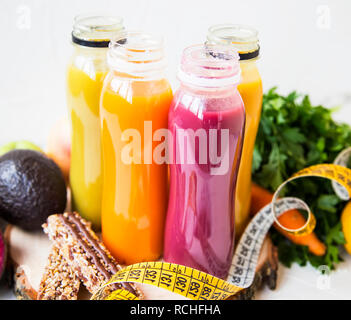 Frische organische Säfte in Flaschen, Rot, Orange, Gelb, gesunde Säfte mit grünen, Gemüse, Obst, Müsliriegel, gesundes Wohnen und Leben Stockfoto