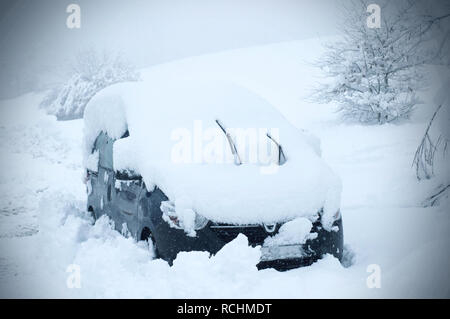 Ein Auto im Schnee gesperrt, nach einem Schnee Zyklon. Schnee bedeckt Auto während der Schnee fällt noch. Stockfoto