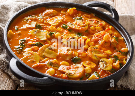 Vegan indischen Pilz Curry mit Spinat, Tomaten und Kichererbsen Nahaufnahme in der Pfanne. Horizontale Stockfoto