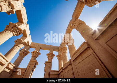 Trajan Kiosk im Philae Innenansicht. Säulen geschmückt mit hyeroglyphs. Lens flare Effekt von der Sonne. Stockfoto