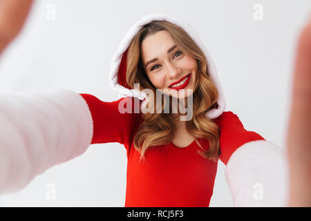 Porträt der jungen Frau 20 s trägt der Weihnachtsmann rot Kostüm lächelnd und unter selfie Foto auf weißem Hintergrund Stockfoto