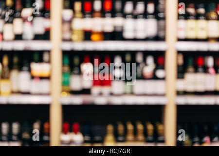 Unscharfes Bild von Regalen mit Flaschen Wein. Stockfoto