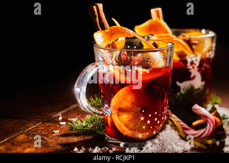 Traditionelle Weihnachten Glühwein oder Glühwein süß würzige Rotwein mit Zimt in zwei Glas Becher mit Zuckerstangen serviert und Platz kopieren Stockfoto