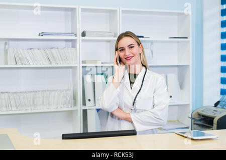 Junge Rezeptionistin talkingto der Kunde Patient im Krankenhaus Stockfoto