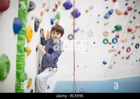 Süße kleine Vorschule Junge, Kletterwand im Innenbereich, Spaß, aktive Kinder Stockfoto