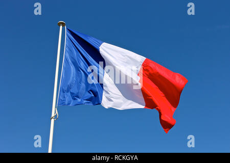 Flagge Frankreich wellenartig über einen blauen Himmel Stockfoto