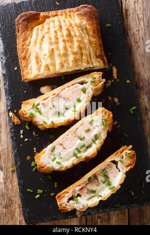 Traditionelle Blätterteig Torte gefüllt mit Lachs mit Käse close-up auf den Tisch. Vertikal oben Ansicht von oben Stockfoto