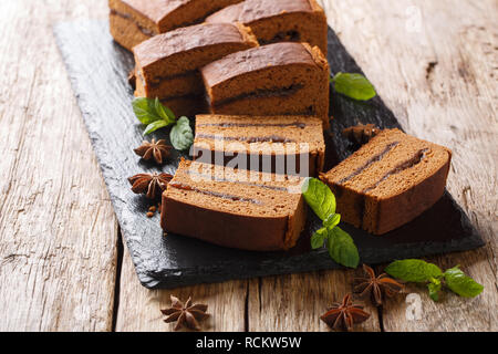 Ingwer Schokolade Polnisch Kuchen piernik mit Pflaumenmus close-up auf einer Schiefertafel Board auf dem Tisch. Horizontale Stockfoto