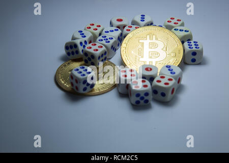 Bitcoin cryptocurrency Tokens in der Mitte der Würfel auf dunklem Hintergrund weiß. Investitionen, Währung, Unsicherheit, Risiko und Belohnung, Exchange Medium, Reichtum, Stockfoto