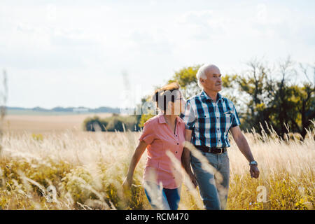 Senior Paar hinunter einen Pfad in der Natur Stockfoto