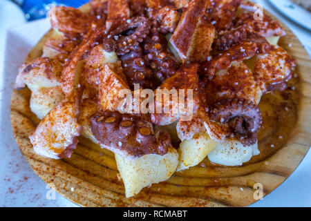 Octopus (Pulpo a la Gallega) serviert auf einer Holzplatte. Cádiz, Spanien Stockfoto